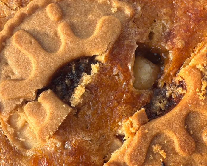 A rectangular slice of golden-brown baked pie or pastry with two embossed biscuit-like cookie pieces on top, shown on a plain white background.